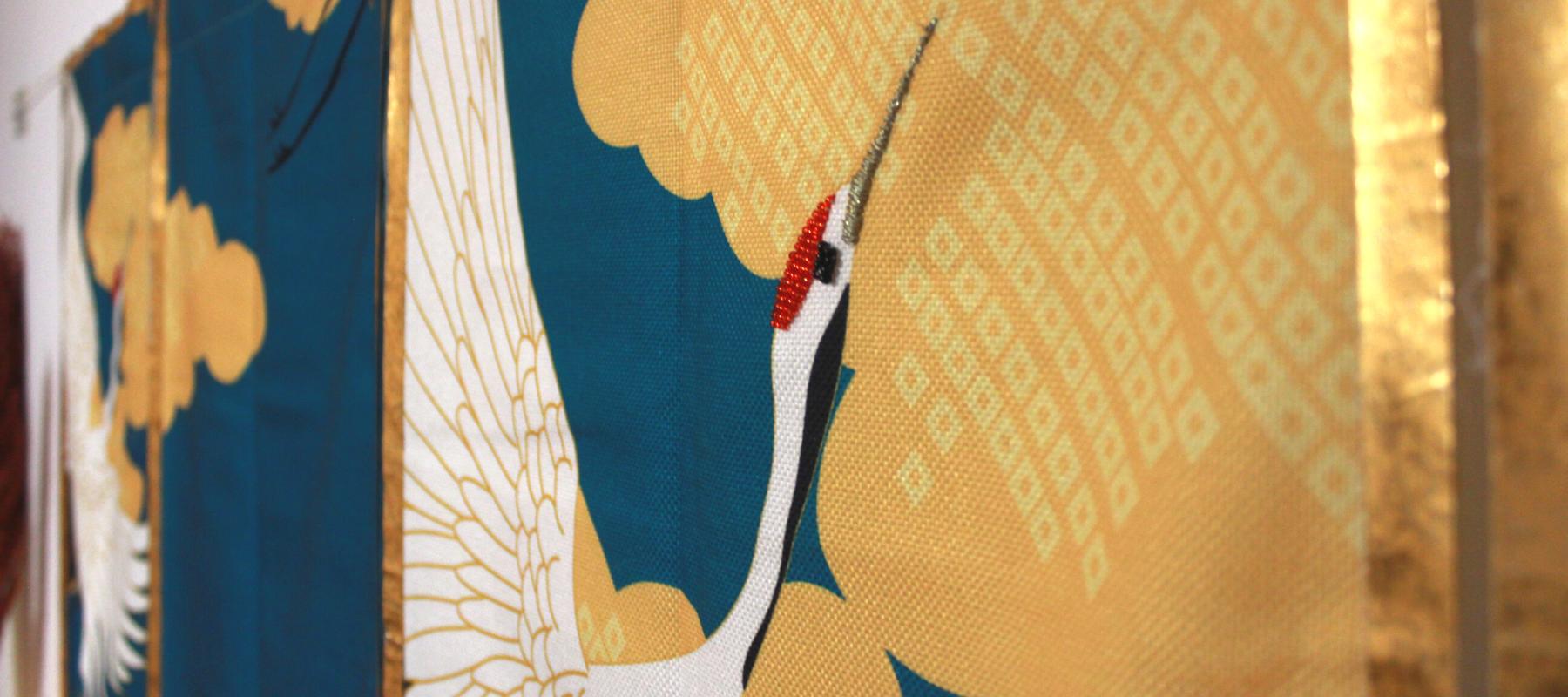 Crane wall tapestry with embroidered beaks and gold border maximalist style
