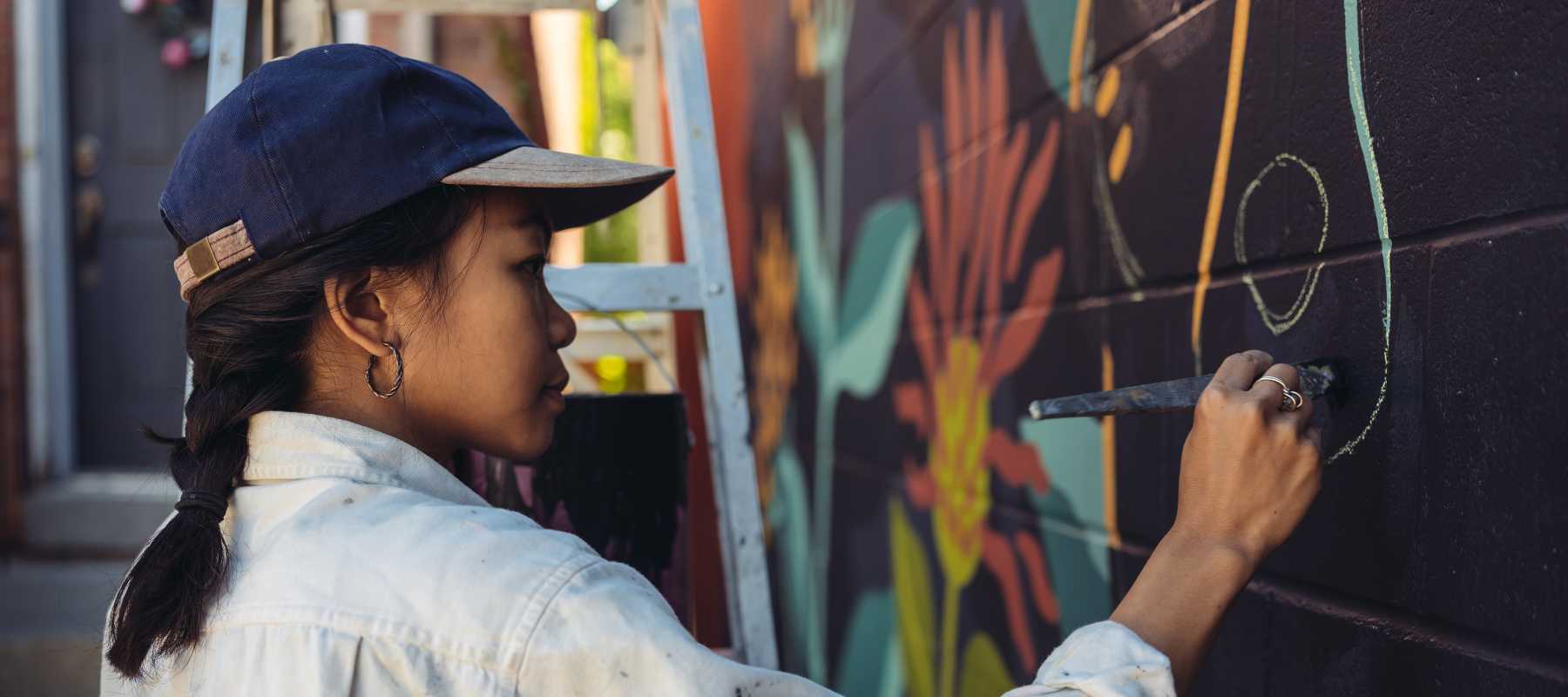 artist woman painting a flower mural