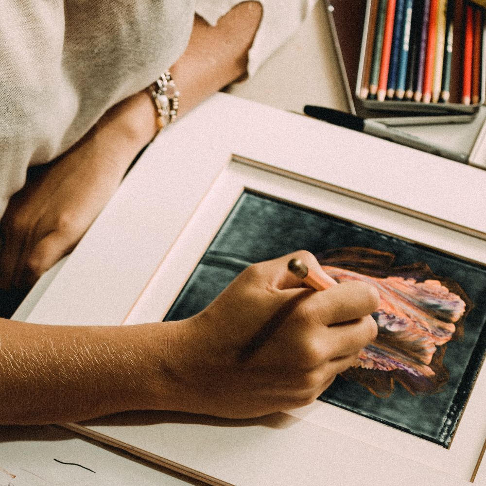 an artist finishing a color pencil drawing ready for a certificate of authenticity