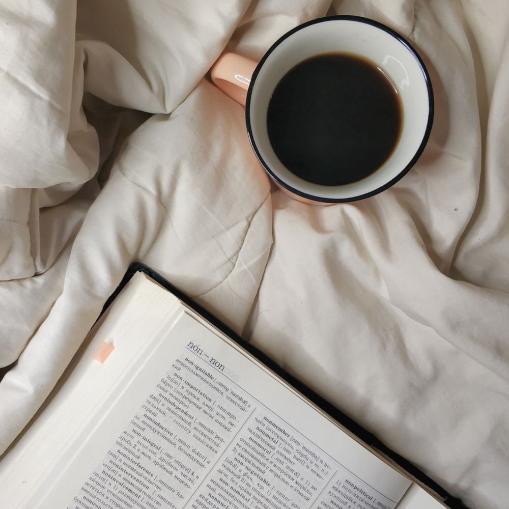 definition of certificate of authenticity in a dictionary on a bed with a cup of coffee